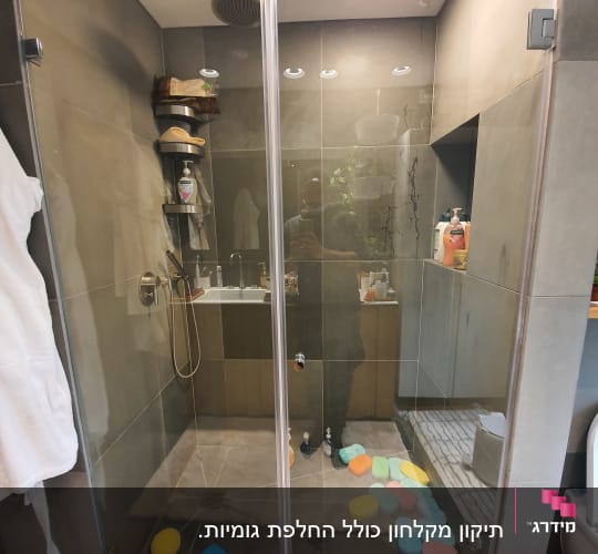מקלחת עם ראש גשם, ספוגים צבעוניים ומדף עם מוצרים